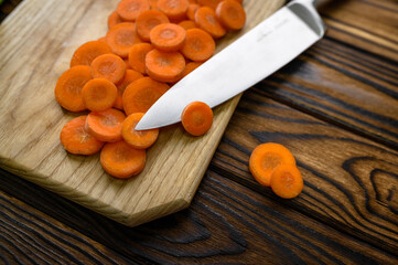 Fresh cutted carrot and knife, wooden background