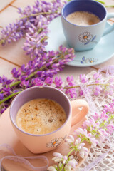 coffee or cappuccino mug and lupins flowers on the table