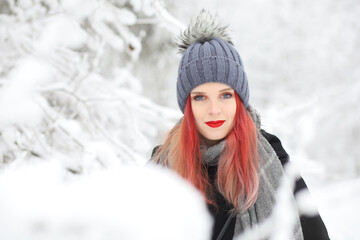 Front view portrait of attractive red hair girl smiling in wintry nature.