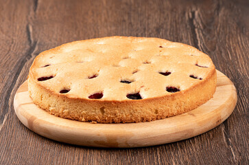 Blackberry pie on a cutting board over a wooden background.