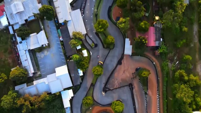 4k Aerial Top Down View: Drone Follows A Racing Kart On A Track At Sunset. Racing Go-karts Competition. Birdseye View. Aerial Footage Of Go-karts, Amusement Park, Khao Yai Thailand