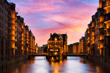 The Warehouse district Speicherstadt during beautiful twilight pink sunset in Hamburg, Germany. Illuminated warehouses in Hafencity quarter in Hamburg.