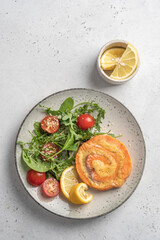 Salmon Pinwheel stuffed with cheese with salad and lemon