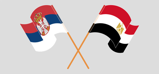 Crossed and waving flags of Serbia and Egypt