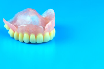 plastic removable denture on a blue background