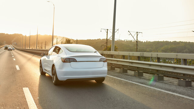 Rear view of car moving along aspalted city road