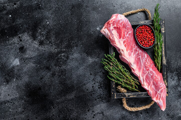 Raw veal calf short spare rib meat with thyme and rosemary. Black background. Top view. Copy space