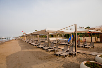 Beach near the sea with sun loungers and parasols