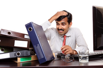 Indian young businessman tension on his bending works on white.