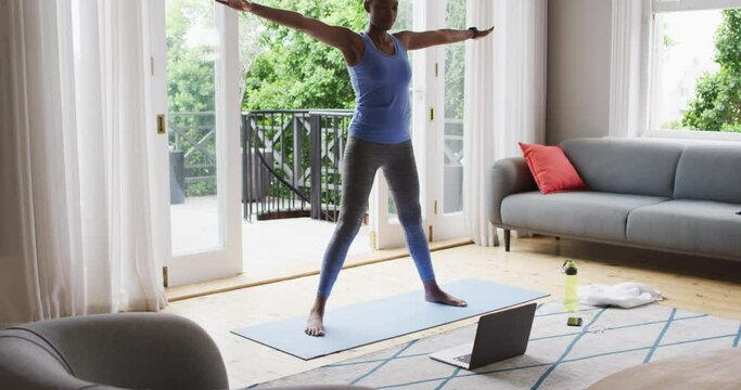 African american woman performing stretching exercise at home