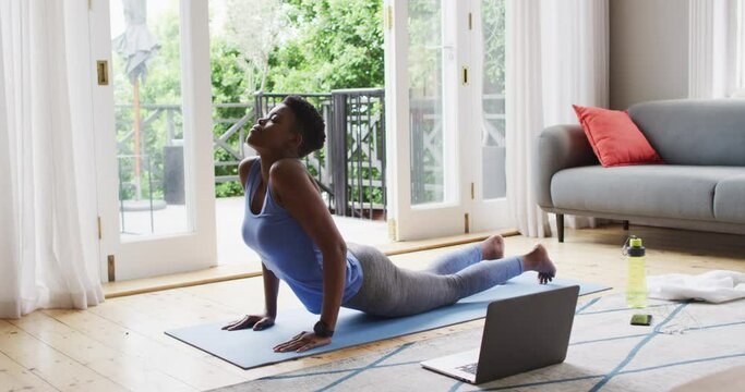 African american woman performing stretching exercise at home
