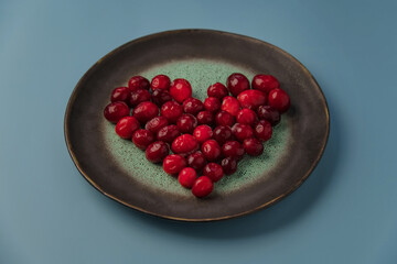 heart shaped cranberries, on a blue background. Top view