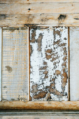 Peeling paint on an old wooden plank tile, integrated as a part of a shutter door. Close up.