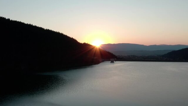 Golden Sunset Setting Behind Mountains In Frumoasa Dam, Romania. - aerial reveal