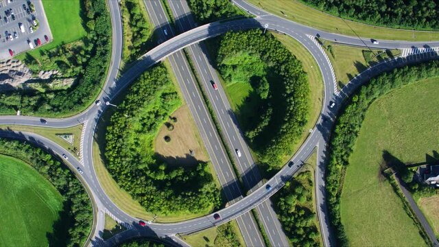 Top down aerial shot of intricate roundabout over freeway in Ireland.