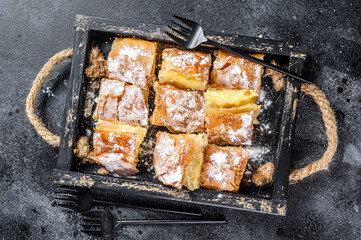 Sliced Bougatsa pie pastry with semolina custard cream. Black background. Top view