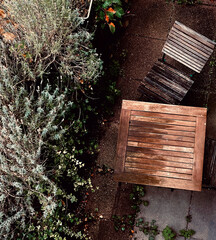 An abandoned table with a chair in the garden after the rain