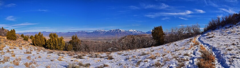 Fototapeta na wymiar Winter Landscape panorama Oquirrh and Wasatch mountain views from Yellow Fork Canyon County Park Rose Canyon rim hiking trail by Rio Tinto Bingham Copper Mine, Utah. United States.