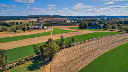Fototapeta na wymiar Aerial View of Multiple Farms and Train Tracks going Thru Them on a Beautiful Summer Day