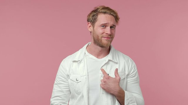 Shocked amazed bearded young man 20s years old in white casual clothes isolated on pink background studio. People lifestyle concept. Pointing fingers himself ask say who me no thanks i do not need it
