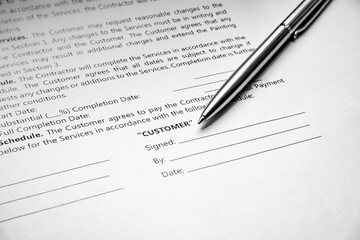 Close-up of a silver pen on docunent contract. Legal contract signing. Buy sell real estate contract agreement. Customer sign on document paper with silver pen