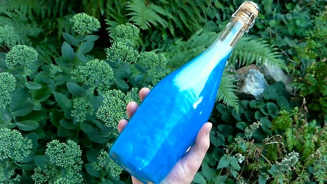Bottle blue Elixir in hand