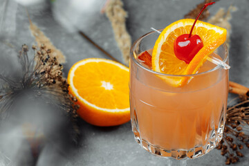 Mulled wine in glass glasses with apples orange and cinnamon. Hot Christmas drink on a grey...