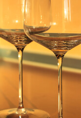 Empty wine glasses on thin legs in the interior, the container for the alcoholic beverage. Yellow background. High quality photo