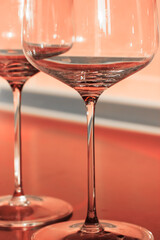 Empty wine glasses on thin legs in the interior, the container for the alcoholic beverage. Yellow background. High quality photo