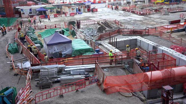 Building construction site with construction workers walking around during the day