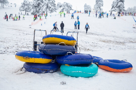 Colorful snow sledding tubes for kids playing at winter