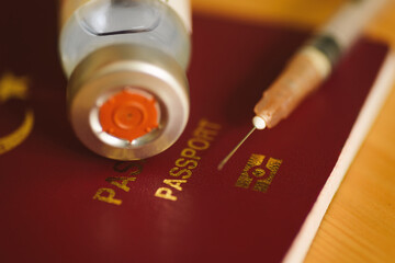 Close up shot of a coronavirus vaccine bottle with a Red colored Turkey's passport.