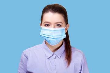 Coronavirus, masked woman.Studio portrait of a young woman wearing a face mask, looking at camera