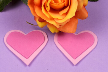 Yellow flower on lilac background with hearts