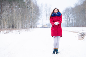 Fototapeta na wymiar Young woman in red coat walk on winter road