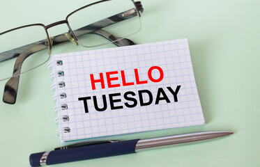 Text Hello Tuesday on business card with eyeglasses and pen