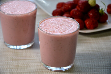 Glass of strawberry milk close up. Fresh strawberries in a glass of natural milk. Vitamin fruit diet cocktail.