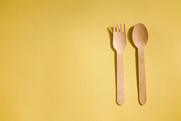 flat lay wooden spoon and fork isolated on yellow background