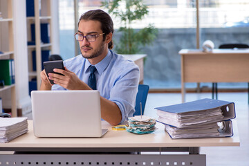 Young male accountant in budget planning concept
