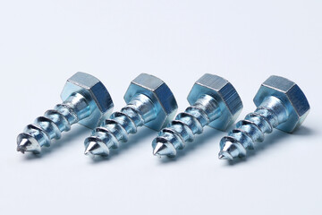 Hex head screws lie on a white background. Four screws close up. Steel screws for installation.