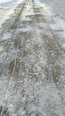 Asphalt road, track partially cleared of snow