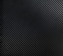 A dark carbon fiber material shot. A dark industrial texture suitable as a background on...