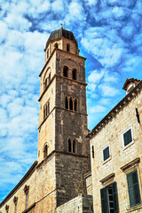 Fototapeta na wymiar Street with medieval buildings and stone belfry of the city of Dubrovnik
