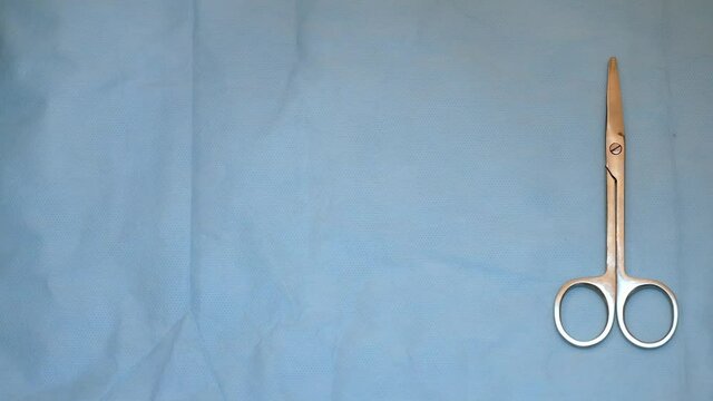 multiple surgery instruments on blue table above view. surgeon put down surgical tools to table top.