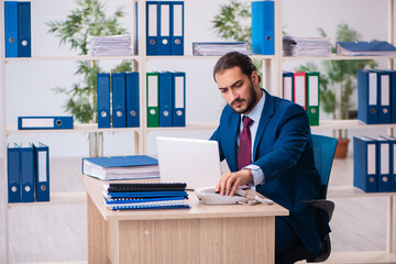 Young male employee and too many work in the office