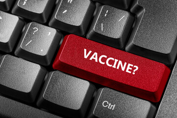 Coronavirus Covid-19 concept. Computer keyboard with red key Vaccine and question mark.