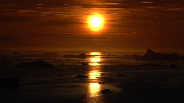 Sun beam and sunlight on molten icebergs in arctic circle, ilulissat disko bay, greenland