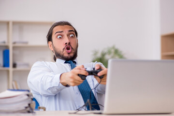 Young male employee playing joystick games during his break