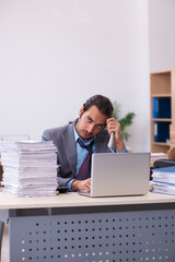 Young male employee unhappy with excessive work in the office