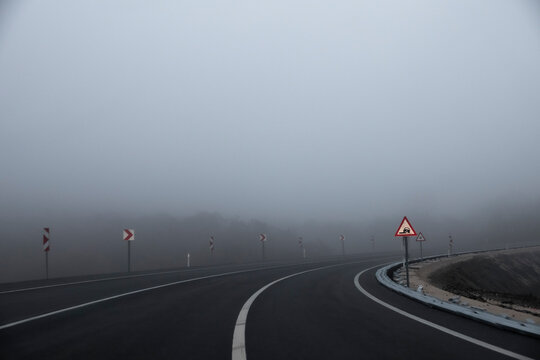 Misty, fogy road and traffic signs.